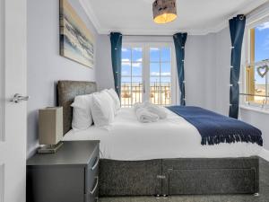 um quarto com uma cama e uma secretária com uma janela em Pass the Keys Sunset Cottage Luxury Home On The Seafront em Herne Bay