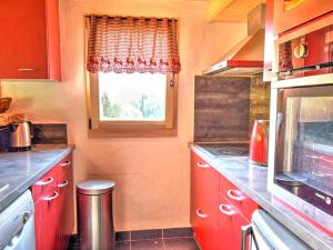 uma cozinha com armários vermelhos e uma janela em Chalet Montriond, 4 pièces, 5 personnes - FR-1-524-46 em Montriond