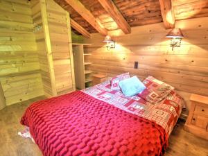 um quarto com uma cama vermelha num chalé de madeira em Chalet Montriond, 4 pièces, 5 personnes - FR-1-524-46 em Montriond