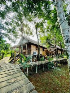 a house with a wooden walkway in front of it at Bamboo Hideaway, Bungalows with Pool and Kitchen in Ko Mak