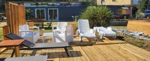 a group of white chairs sitting on a deck at La Caravane LE NID DOUILLET in Ponte-Leccia