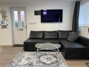 a living room with a black couch and a table at Inviting 1-Bed Studio in Manchester & feel at home in Manchester