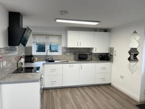 una cucina con armadietti bianchi e forno a microonde di Inviting 1-Bed Studio in Manchester & feel at home a Manchester