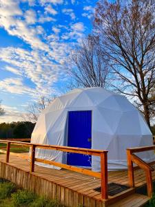 a white tent with a blue door on a deck at Modern Luxury Dome near Texarkana, Texas 