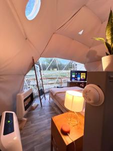 a room in a tent with a bed and a desk at Modern Luxury Dome near Texarkana, Texas 
