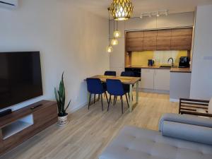 a living room with a table and chairs and a kitchen at Apartament Opal 34 Family & SPA in Dziwnów