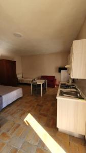 a room with a kitchen and a bedroom with a bed at Il borgo di Cornillo in Meggiano