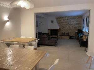 a living room with a couch and a table and chairs at gitele25 - 10mn du Puy duFou in La Verrie