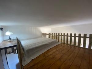 een slaapkamer met een bed en een houten vloer bij Oasi delle palme in Augusta