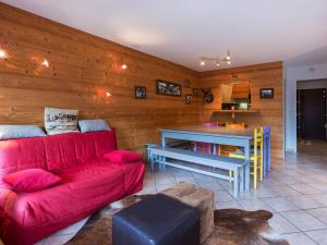 a living room with a red couch and a table at Appartement La Clusaz, 3 pièces, 8 personnes - FR-1-437-36 in La Clusaz