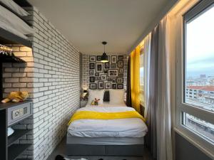 een kleine kamer met een bed en een bakstenen muur bij Appartement Flandre in Parijs