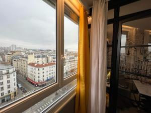 een raam met uitzicht op de stad bij Appartement Flandre in Parijs
