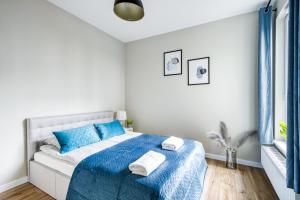 a white bedroom with a blue bed with towels on it at Warsaw Inside Airport & Business Premium in Warsaw