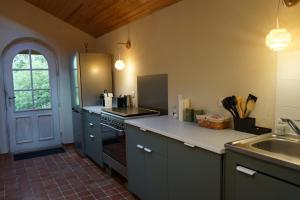 a kitchen with a refrigerator and a sink in it at Les Jardins de Bathilde - Au sein du Château de Bothané in Guidel