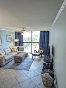 sala de estar con sofá y mesa en Biloxi Beach Condo-B en Biloxi