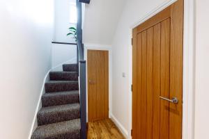 um corredor com uma porta de madeira e escadas em Chute House 4 bed house private garden city center em Exeter