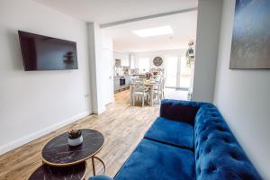 uma sala de estar com um sofá azul e uma mesa em Chute House 4 bed house private garden city center em Exeter