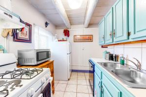 a kitchen with blue cabinets and a white refrigerator at West Berger Charmer Unit B in Santa Fe