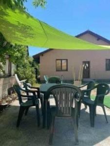 a table and chairs with a green umbrella at Dom pri kúpalisku Thermalpark na Malotejedskej in Dunajská Streda