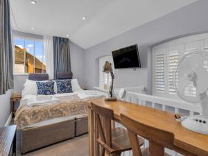 a bedroom with a bed and a desk and a fan at Pass the Keys Unique Newly Refurbished Home in Canterbury