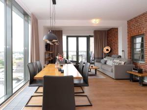 een woonkamer met een tafel en stoelen en een bank bij Ohlerich Speicher App_ 44 in Wismar