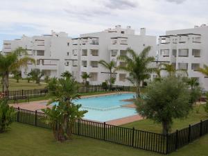 un complejo de apartamentos con piscina y palmeras en Luxury South Facing Golf Course Apartment & Pool in Roldan, en Las Pedreñas