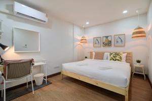 a bedroom with a large white bed and a desk at Bangkok Watergate Townhouse 曼谷中心水門家 in Bangkok