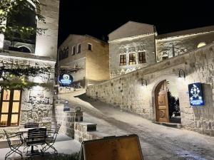 a building with a table and chairs in front of it at Sinasos Evleri in Nevsehir