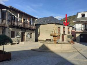 una fontana davanti a un edificio con bandiere di www luabierzo a Molinaseca