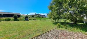 a grassy field with a tree and a house at Lann Vras - Maison proche littoral - K25 in Locmariaquer