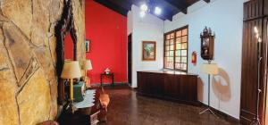 a living room with red walls and a stone wall at Camila´s Hotel in San Pedro Sula