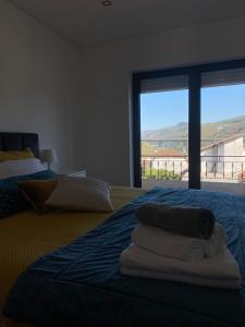 Un dormitorio con una cama con toallas. en CasaMaeDouro, en Peso da Régua