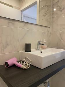 Un lavabo de baño con un secador de pelo rosa sobre un mostrador. en CasaMaeDouro, en Peso da Régua 34 fotos más