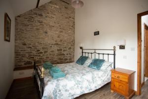 a bedroom with a bed and a stone wall at 2 Beacon View Barn in Felindre