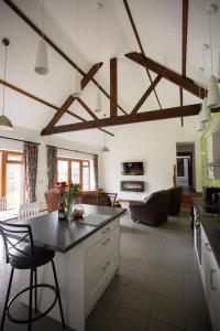 a kitchen and living room with wooden beams at 2 Beacon View Barn in Felindre