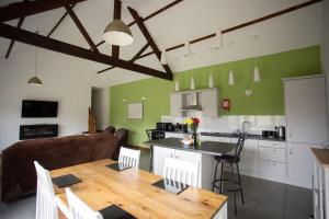 a kitchen and dining room with a wooden table in a room at 2 Beacon View Barn in Felindre