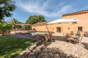 uma piscina com um guarda-sol, uma mesa e cadeiras em Sa Pobla 21842 Mallorca6 em Sa Pobla