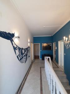 a hallway of a house with blue walls and stairs at Impact Beach House in Estoril