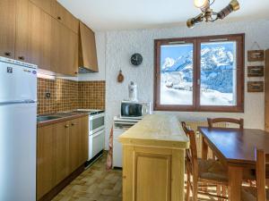 a kitchen with a table and a window with snow at Appartement La Clusaz, 2 pièces, 4 personnes - FR-1-437-83 in La Clusaz