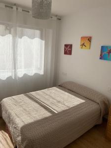 1 dormitorio con cama y ventana en Apartamento céntrico con vistas y cerca de playa, en Puentedeume