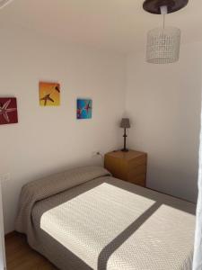 um quarto com 2 camas, um candeeiro e pinturas em Apartamento céntrico con vistas y cerca de playa em Puentedeume