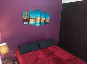 a bedroom with a bed with purple walls at Precioso piso en la playa de Madrid a 45 min del centro de la ciudad in Madrid