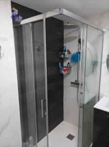 a shower with a glass door in a bathroom at Precioso piso en la playa de Madrid a 45 min del centro de la ciudad in Madrid