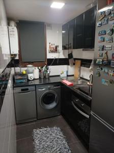 a kitchen with a washing machine and a refrigerator at Precioso piso en la playa de Madrid a 45 min del centro de la ciudad in Madrid