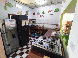 a kitchen with a stove and a refrigerator at Hostal Casa La Candelaria in Mompós