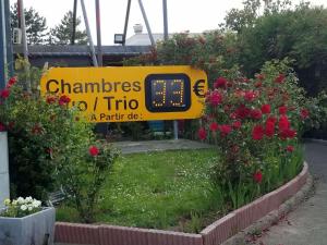 a sign with a clock in the middle of flowers at N&Z HOTELS in Trappes