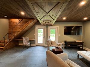 a living room with a vaulted ceiling with wooden beams at Modern Industrial Farmhouse - The Wayback in Orange