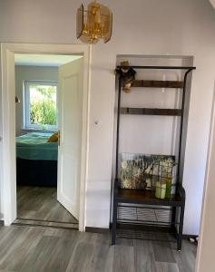 a hallway with a mirror and a room with a bed at Das Krimihaus Ostfriesland in Rhauderfehn