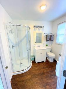 a bathroom with a shower and a toilet and a sink at Hillcrest Inn & Motel in Rapid River