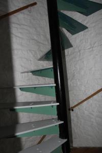 a stack of green and white stairs against a wall at Kingfisher Cottage in High Bentham